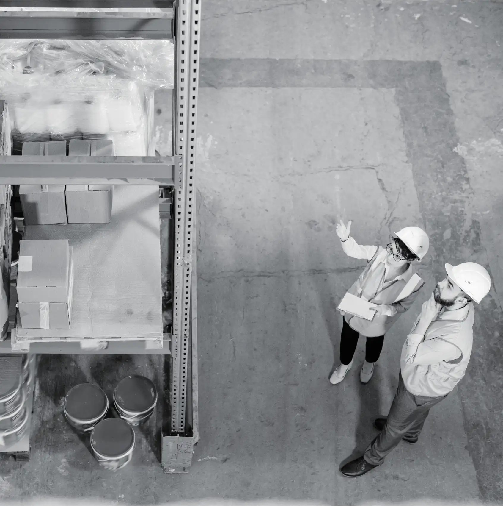Warehouse staff using handheld scanner to check large wrapped cargo and pallets