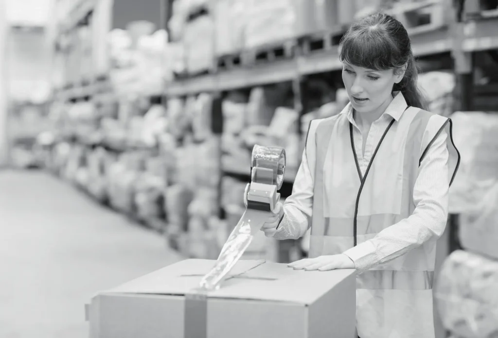 Female warehouse worker scanning barcode on box during order fulfillment process