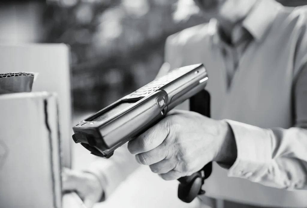 Hand holding barcode scanner during inventory or order processing