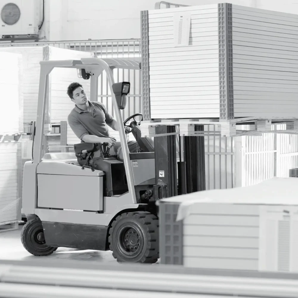 Forklift operator moving large pallet in busy 3PL warehouse