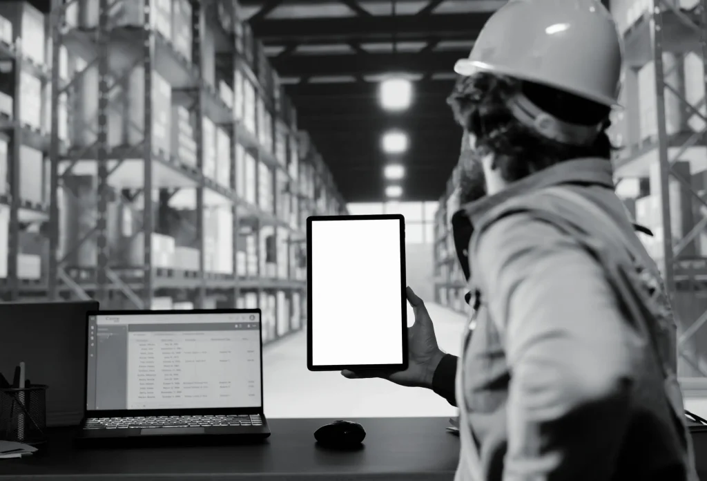 Worker checking live tracking tablet in warehouse
