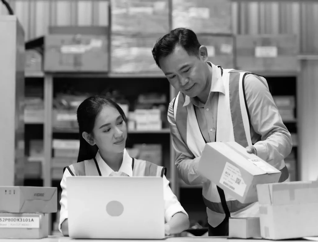 Two warehouse specialists checking packages with real-time tracking